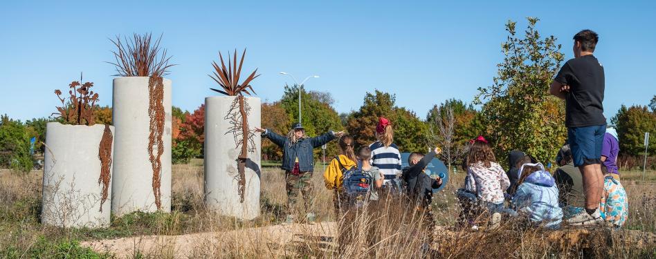 A teacher demonstrates at an outdoor learning center.