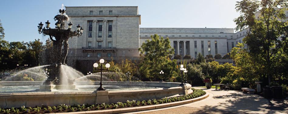 A fountain in front of a large building.