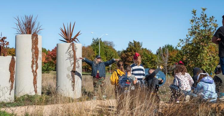 A teacher demonstrates at an outdoor learning center.