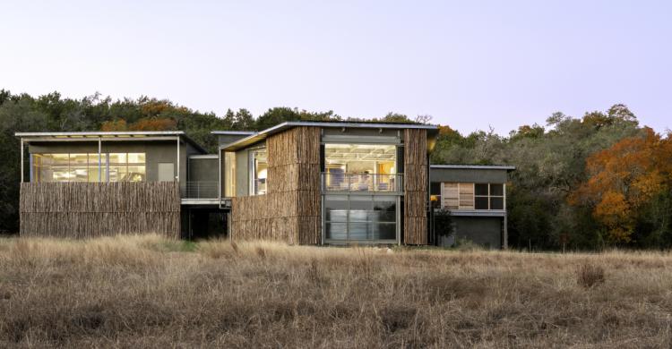 A rustic wood building seen across a field.