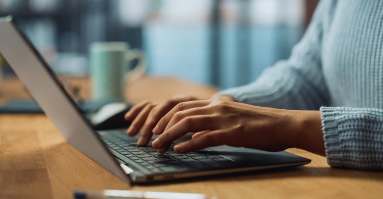 A person typing at a laptop.