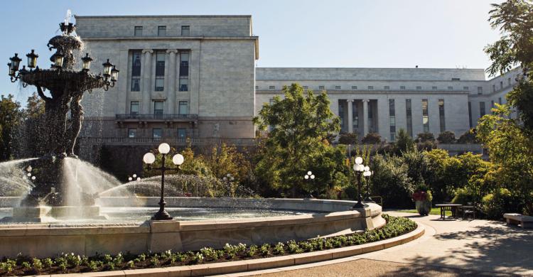 A fountain in front of a large building.